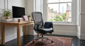 Premium orthopaedic ergonomic office chair positioned beside a desk in a bright London apartment